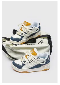 Retro sneakers met dikke witte veters en blauwe denim panelen op een canvas tas