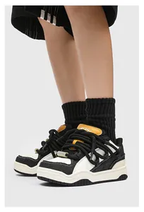 Gedetailleerde weergave van zwart-witte chunky sneakers met gele accenten en dikke veters