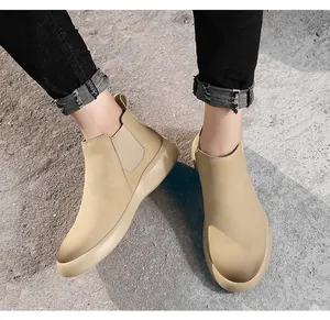 Gedetailleerd overzicht van stijlvolle beige Chelsea boots voor heren op beton