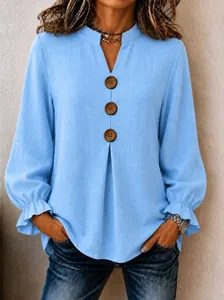 Detailed view of women's light blue V-neck blouse featuring rustic wooden buttons