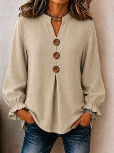 Beige long-sleeved V-neck blouse with decorative wooden buttons and ruffled cuffs.