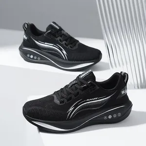 Scarpe da corsa nere da uomo in mesh traspirante presentate su eleganti podi bianchi