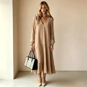 Elegante vestido maxi beige de manga larga con cuello en V y falda de volantes en vista completa.