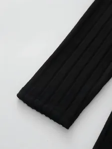Close-up detail of the ribbed knit cuff on a slim black long-sleeve autumn dress