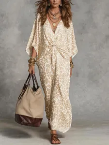 Full view of a leopard print V-neck maxi dress styled with gold jewelry and a tote bag