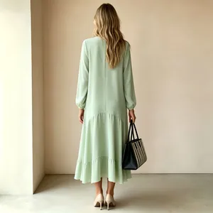 Vista posterior de un vestido maxi verde menta de manga larga con dobladillo largo