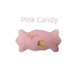 Gros plan sur un jouet sonore en peluche pour animaux en forme de bonbon rose brodé