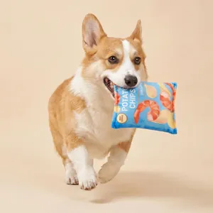 Cane Corgi che gioca con un giocattolo sonoro a forma di sacchetto di patatine ai gamberetti