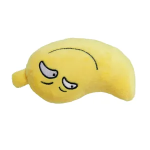 Gros plan sur un jouet en peluche banane jaune avec expression brodée grincheuse