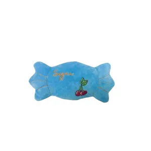 Détail d'un jouet en peluche pour animaux en forme de bonbon bleu avec broderie cerise