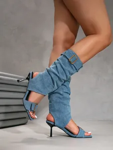 Close-up view of denim stiletto high heel sandals with slouchy leg wrap and buckle