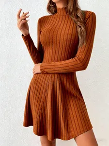 Detail of burnt orange mock neck ribbed knit A-line long sleeve dress showing texture.