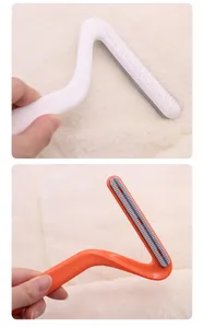 Close-up detail view of double-sided pet hair remover in white and orange colors for home