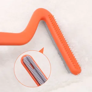 Orange double-sided pet hair remover tool for carpets and clothes shown in detail view