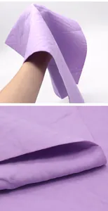Gros plan sur la texture douce en similicuir violet d'une serviette absorbante pour animaux.