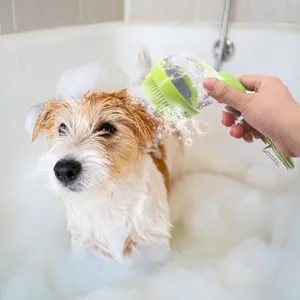 Green long-handle pet bath brush and massager tool used on a dog in bubbles