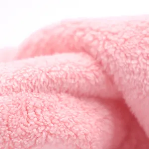 Detalle de tela de microfibra rosa absorbente para el guante toalla de baño de mascotas.