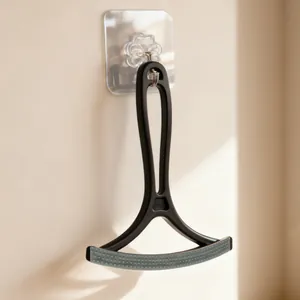 Double-sided pet hair remover scraper for carpet and sofa cleaning hanging on wall hook