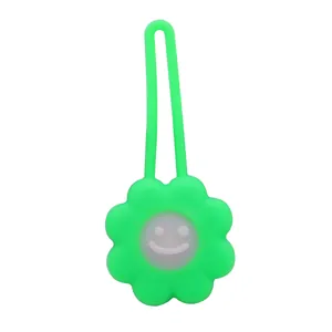 Green flower-shaped LED pet safety pendant for night walking with smiley face.