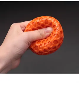Primo piano che mostra l'elasticità della pallina giocattolo per cani TPR arancione