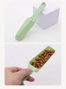 Detail showing the green plastic pet food scoop filled with dry kibble for portioning.