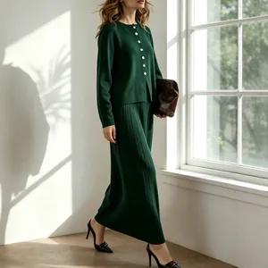 Detail of dark green knitted cardigan and pleated long skirt two-piece set in window light