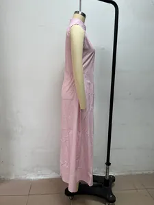Side profile of a pink minimalist sleeveless maxi dress with a stand collar.