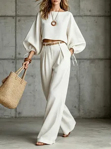 Full view of white lantern sleeve crop top and matching high-waisted wide-leg trousers outfit
