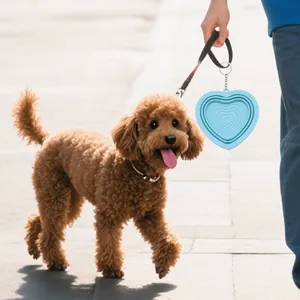 Portable blue heart-shaped collapsible silicone pet bowl on a dog leash outdoors