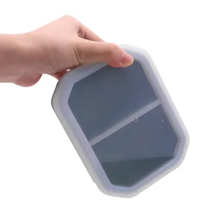 Gray two-compartment silicone pet bowl for cat food and water held in hand for display