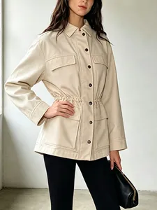 Nahaufnahme einer beigen Utility-Jacke mit Kordelzug an der Taille und Pattentaschen.