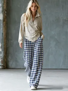 Mannequin portant un ensemble pantalon large à carreaux bleus et haut en tricot beige