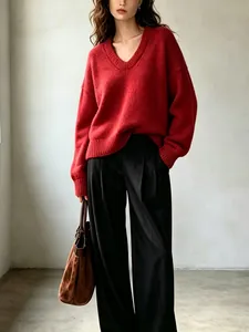 Vista dettagliata della morbida texture di un maglione rosso oversize con scollo a V da donna
