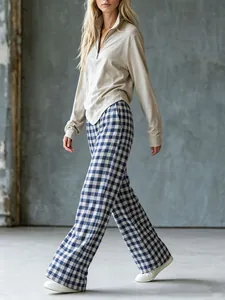 Mannequin portant un pantalon large à carreaux bleus et un haut en maille beige zippé