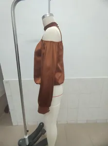 Side view of a chic matte satin off-shoulder long sleeve blouse in rust brown color