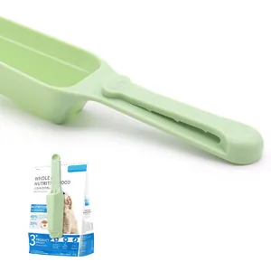 Multi-functional green pet food scoop with built-in bag sealing clip for dogs and cats.