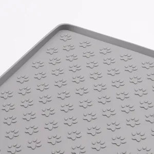 Waterproof grey silicone pet feeding mat with anti-slip paw patterns and raised edges