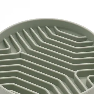 Sage green silicone slow feeder dog bowl with maze pattern close-up view