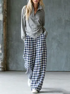 Vue détaillée d'un pantalon large à carreaux vintage et d'un haut en tricot gris zippé