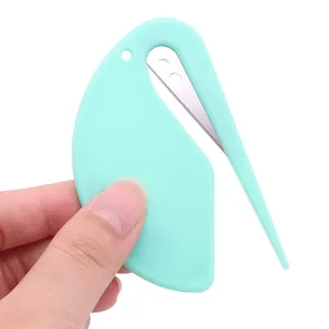 Strumento mini per la cura degli animali verde menta e tagliacarte su bianco