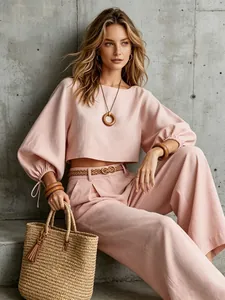 Two-piece linen set with a pink puff-sleeve crop top and matching wide-leg trousers.