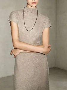 Close-up of elegant oatmeal knit mock neck maxi dress with a minimalist slim fit