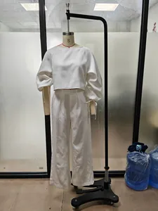 Full view of white two-piece set with puff sleeve crop top and matching trousers