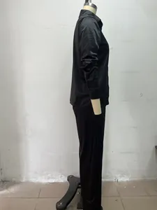 Side profile view of a minimalist black long-sleeved shirt and trousers set for women