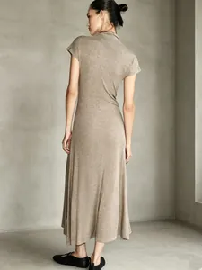 Back view of a minimalist taupe mock neck maxi dress with short sleeves and A-line silhouette