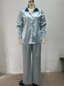 Detail view of a light blue satin long-sleeve shirt and pants set on a mannequin.