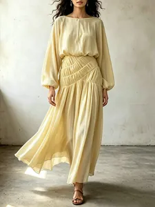 Detailed shot of yellow Bohemian maxi dress featuring lantern sleeves and pleated waist.