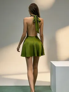 Back view detail of an olive green satin halter mini dress featuring a stylish large bow tie