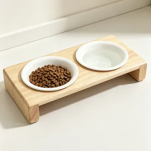 Verhoogde houten voerbak met twee witte keramieken schalen voor voer en water voor huisdieren.