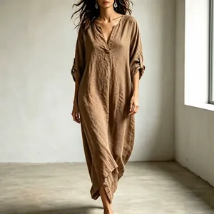 Close-up of loose brown V-neck maxi dress with roll-tab sleeves and linen texture